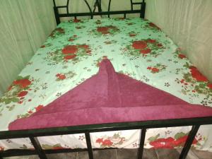 a bed with a blanket on it with flowers on it at Ibus Nawi Homes 2 in Lodwar