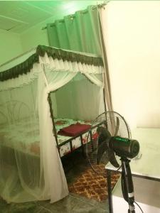 a bedroom with a bed with a fan and a camera at Ibus Nawi Homes 2 in Lodwar