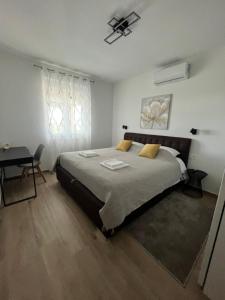 a bedroom with a large bed and a desk at Blackberry Guesthouse in Jastrebarsko