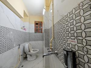 a small bathroom with a toilet and a sink at Evara Stays Backpackers Hostel in Kolkata +69 photos