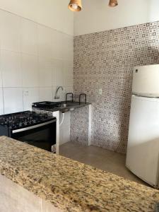a kitchen with a stove and a white refrigerator at CASA ESTRELA e SOL in Barra de Jacuípe +28 photos