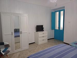 a bedroom with a bed and a tv on a dresser at Domos Ventuno Barumini in Barùmini