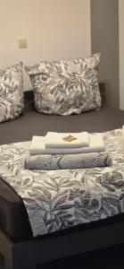 a bed with three towels on top of it at The Rose in Rheinhausen