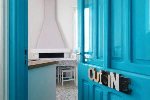 a blue door with a sign on it in a kitchen at Domos Ventuno Barumini in Barùmini +7 photos