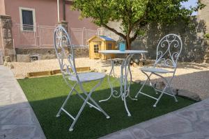 two chairs and a table in a yard at Domos Ventuno Barumini in Barùmini