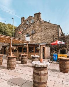 a brick building with tables and umbrellas on a patio at Eagle and Child, Ramsbottom in Bury