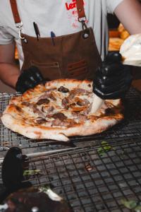 a person is cutting a pizza with a pizza cutter at Langre Homely Rooms in Galizano