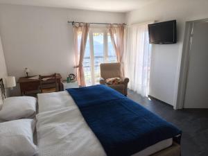 a bedroom with a bed and a television and a chair at Al Ponte in Cademario +92 photos