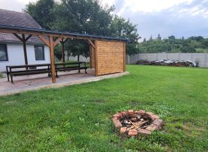 a gazebo and a fire pit in a yard at Apartmán u kolejí D in Kašnice