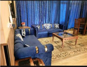 a living room with a blue couch and a table at Panorama Luxury House in Nathia Gali
