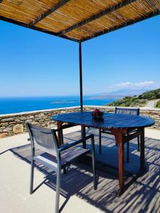 a blue table and chairs on a patio with the ocean at AegeanDeepBlue2 in Apróvaton