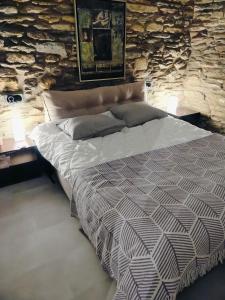 a bed in a room with a stone wall at AegeanDeepBlue2 in Apróvaton
