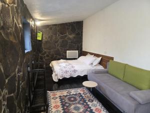 a bedroom with a bed and a couch and a couch at Conacul Ancuței in Brad