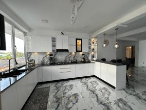 a kitchen with white cabinets and a marble floor at The calm villa in Kandana