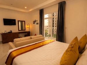 a bedroom with a large bed and a large window at Le Kree Downtown Hotel in Phnom Penh