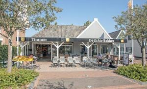 a restaurant with tables and chairs in front of a building at Estrela Do Norte in De Cocksdorp
