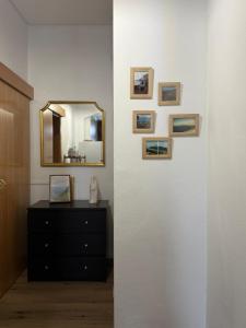a wall with a mirror and a dresser in a room at Casa & Caminho AL in Velas