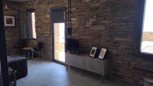 a living room with a stone wall and a television at AegeanDeepBlue2 in Apróvaton
