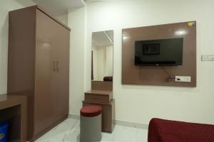 a room with a tv on a wall with at Hotel Panchvati in Durgāpur +7 photos