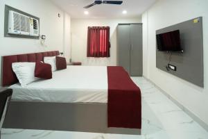 a bedroom with a bed and a tv on the wall at Hotel Panchvati in Durgāpur