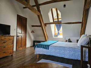 a bedroom with a bed and a dresser and a tv at La Tilia in Saint-Riquier