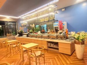 a restaurant with tables and chairs and a counter at Golden Paradise Hotel - SHA PLUS in Karon Beach