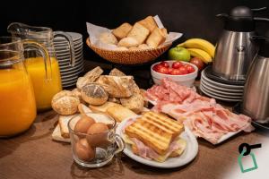 a table with a breakfast of eggs and bread and fruit at Hotiday Milano Risorgimento in Milan
