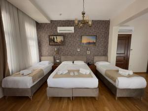 a bedroom with three beds and a chandelier at Nan Hotel in Istanbul