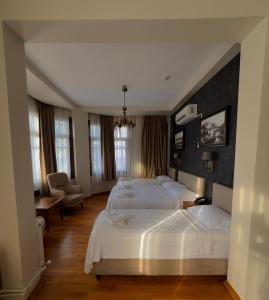 a hotel room with two beds and a chair at Nan Hotel in Istanbul
