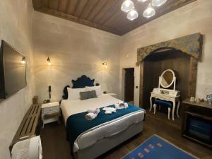 a bedroom with a bed and a vanity and a mirror at Sevdalı Konakları in Avanos