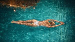 a woman is swimming in a swimming pool at Hotel Fanes in Selva di Val Gardena