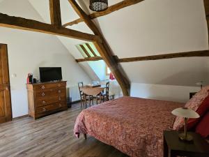 a bedroom with a bed and a dresser and a table at La Tilia in Saint-Riquier +22 photos