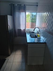 a kitchen with a sink and a refrigerator at Hospedagem estação in Morretes +19 photos
