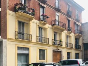 a building with balconies and cars parked in front of it at Isola Blu Milano in Milan