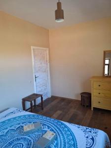 a bedroom with a bed and a dresser and a door at Balto kalno namai, Kernavėje in Kernavė