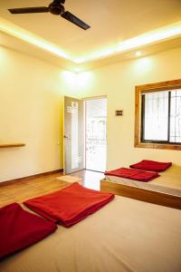 two beds in a room with red sheets at Harmony Hills Ecostay in Nasrāpur