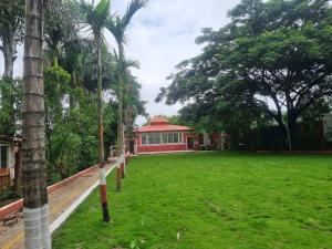 a park with palm trees in front of a building at Harmony Hills Ecostay in Nasrāpur