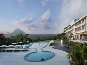 a resort with a pool and a mountain in the background at Gloria Manor in Kenting