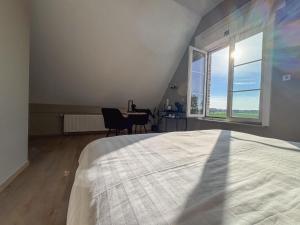 a bedroom with a bed and a desk and a window at Maison Malo in As