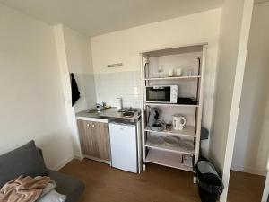 a small kitchen with a sink and a microwave at Résidence du Loir - Le Petit Loft in Vendôme