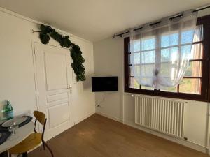 a living room with a window and a table and a television at Résidence du Loir - Le Petit Loft in Vendôme