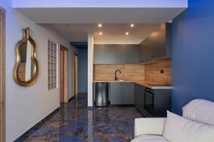 ein Wohnzimmer mit Sofa und eine Küche in der Unterkunft Poseidon Girni Sea View Apartments in Paralia Katerinis