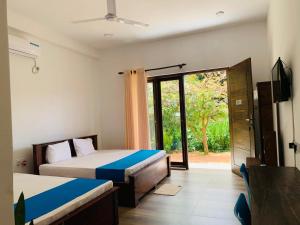 a bedroom with two beds and a sliding glass door at Grandmila Resort in Anuradhapura +142 photos