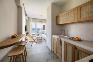 a kitchen with a counter and a dining room with the ocean at Cavo Dio 7 - Beachfront bliss - Cozy Apt Pool Sunset in Káto Dhiminión +18 photos