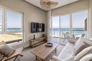 a living room with a view of the ocean at Cavo Dio 7 - Beachfront bliss - Cozy Apt Pool Sunset in Káto Dhiminión