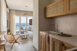 a kitchen and living room with a view of the ocean at Cavo Dio 7 - Beachfront bliss - Cozy Apt Pool Sunset in Káto Dhiminión