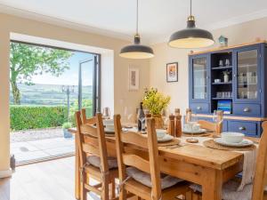 a dining room with a wooden table and chairs at Greenhill in Blackwaterfoot