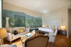 a living room with a bed and a couch at Château De Siran - Hôtel & Spa in Siran +71 photos