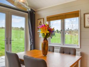 a vase of flowers sitting on a table with chairs at Whitey Top Country Lodge in Pentridge