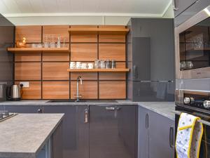 a kitchen with gray cabinets and a sink at Whitey Top Country Lodge in Pentridge